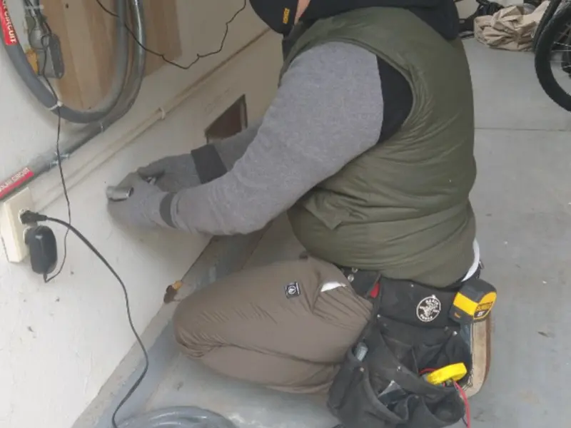 Electrician performing outlet wiring in a Concord garage